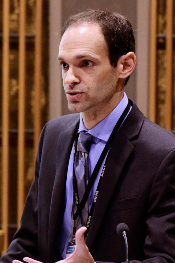 Jonathan Hollander stands at a podium