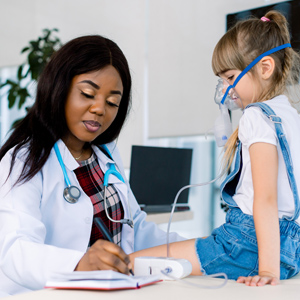 female doctor with young girl patient wearing breathing mask